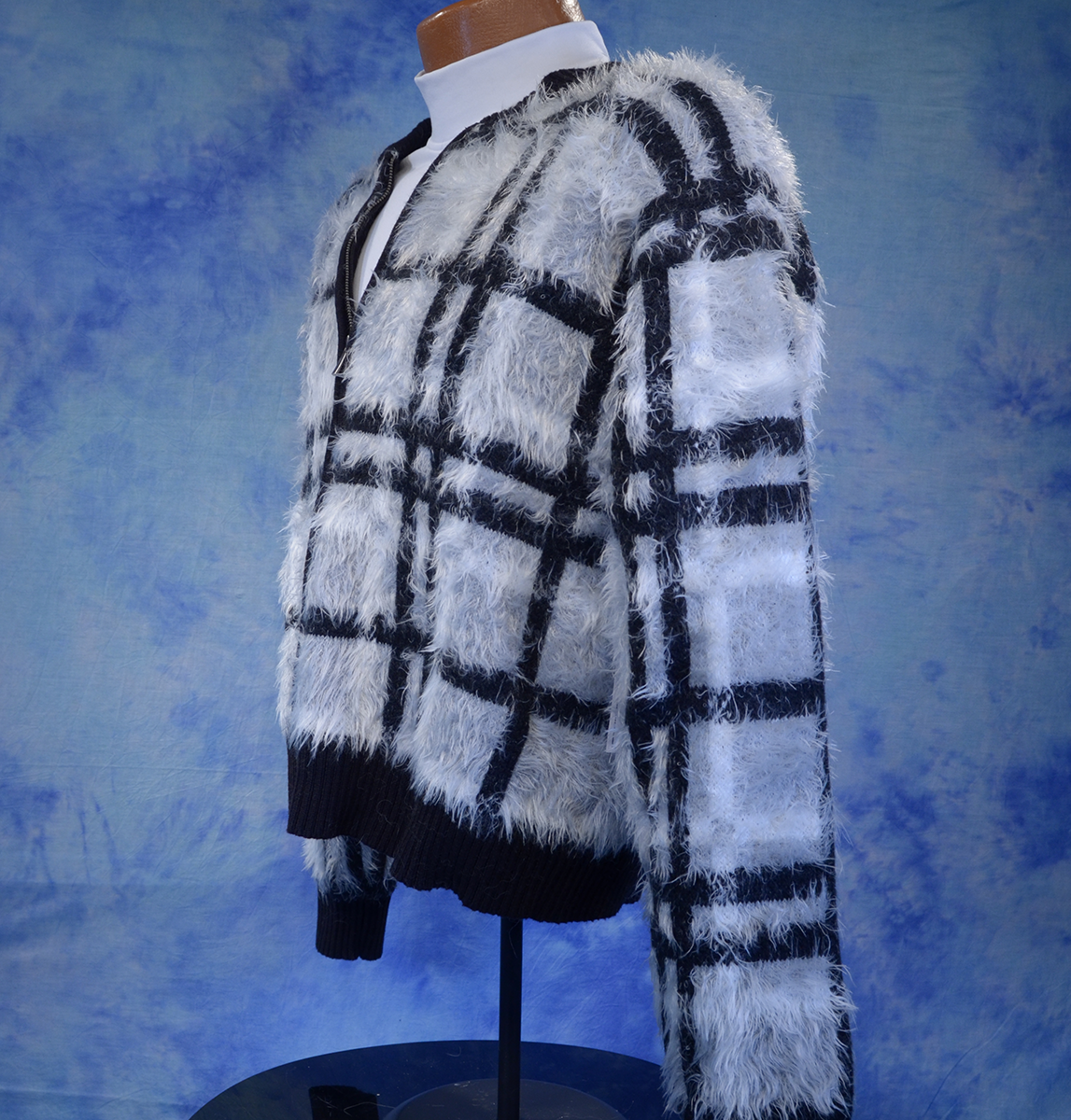 Woman's grey plaid fuzzy eyelash cardigan sweater with black and white check pattern on mannequin