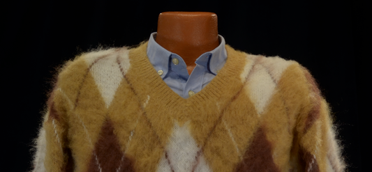 Fuzzy Argyle V-Neck pullover sweater in warm faux mohair with gold, brown, and cream pattern over a blue button-up shirt.