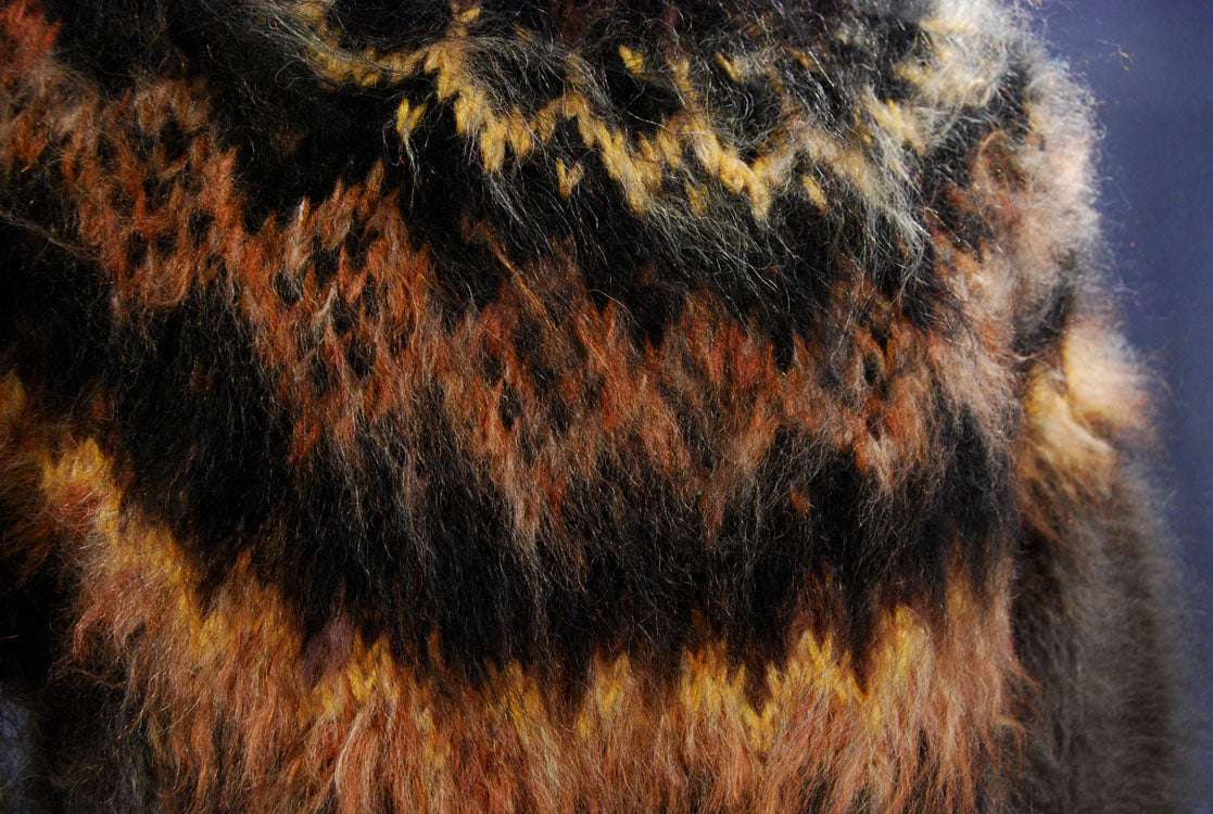 Close-up of men's handknit turtleneck mohair sweater in mink color with warm brown and black pattern