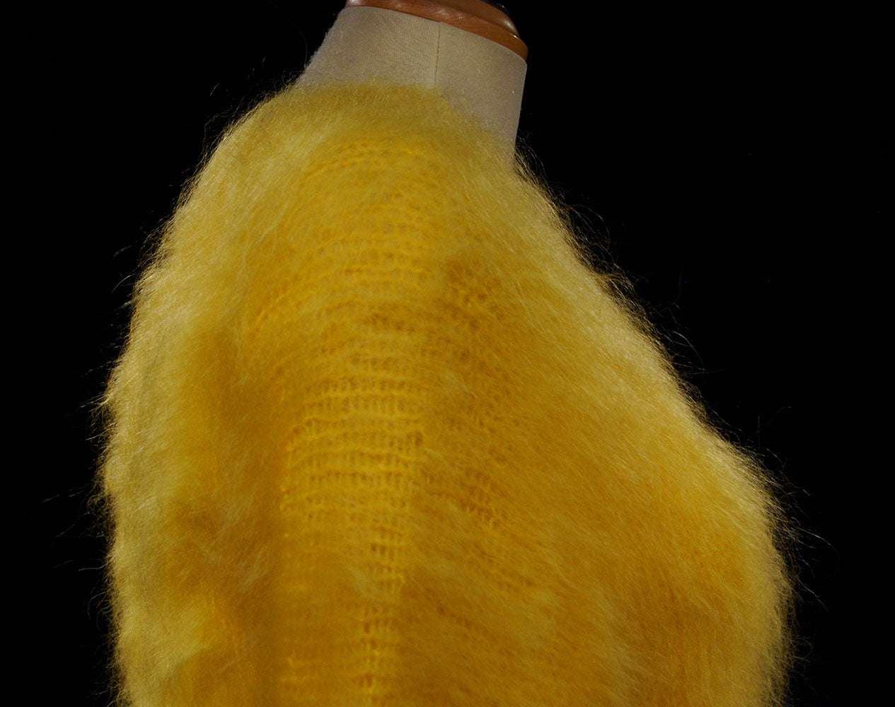 Woman's fuzzy yellow hand-knit mohair sweater with double V-neck design on a mannequin