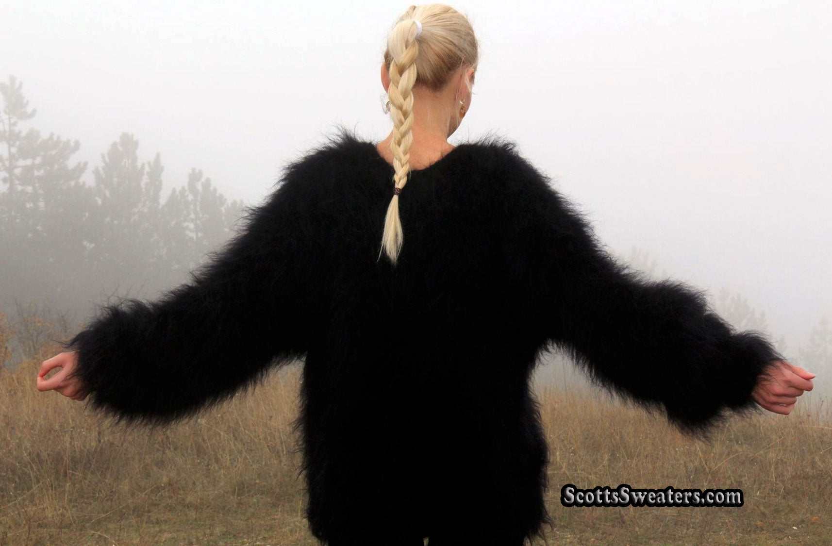 Woman's black very fuzzy mohair sweater with long fibers and roundneck design worn outdoors