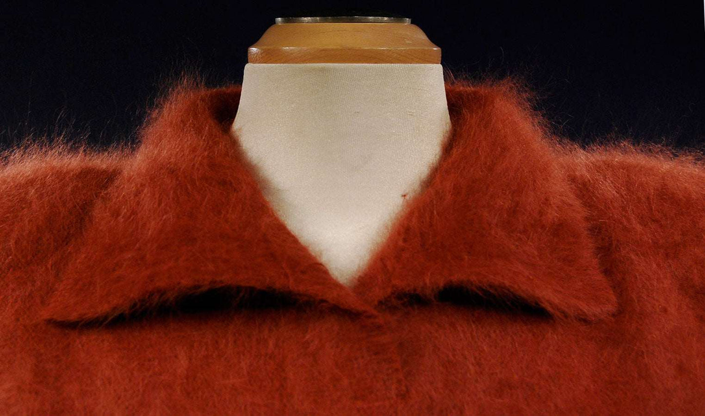 Woman's angora polo-neck sweater in rust color with soft fuzzy texture on mannequin.
