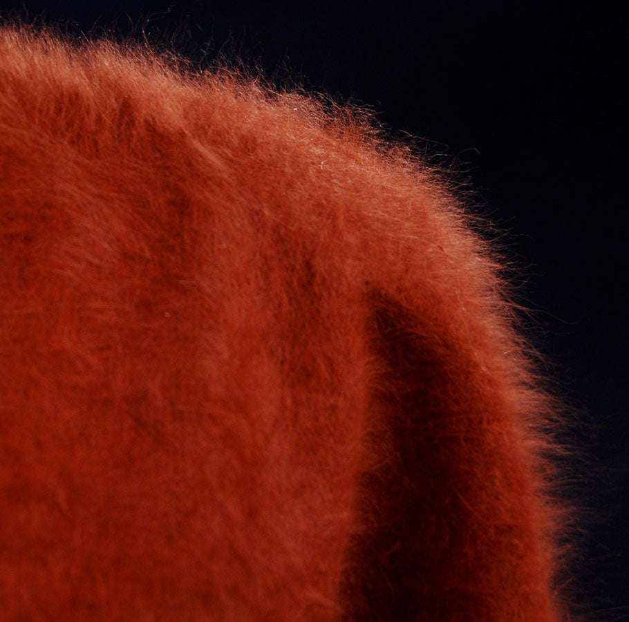 Close-up of soft, fuzzy red woman's angora polo-neck sweater fabric texture