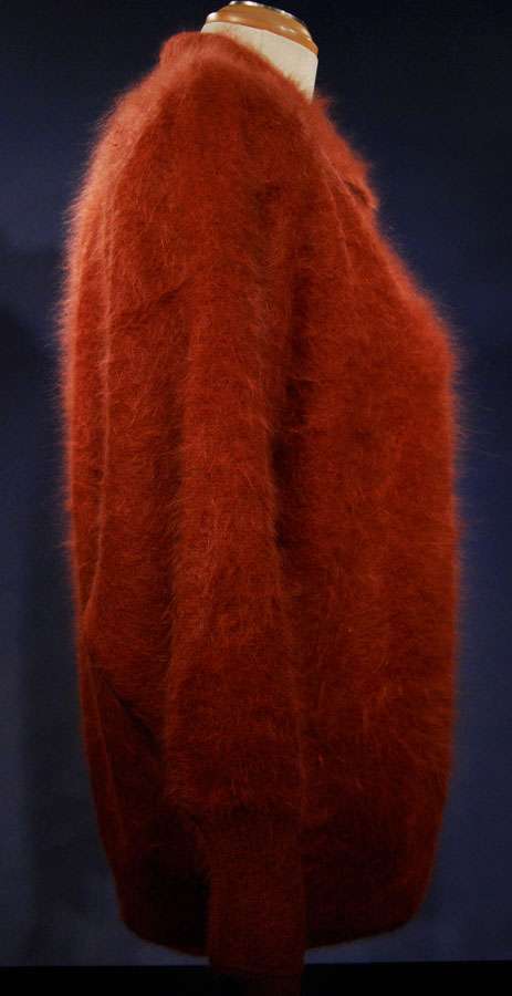 Woman's angora polo-neck sweater in rust color with soft fuzzy texture on mannequin side view