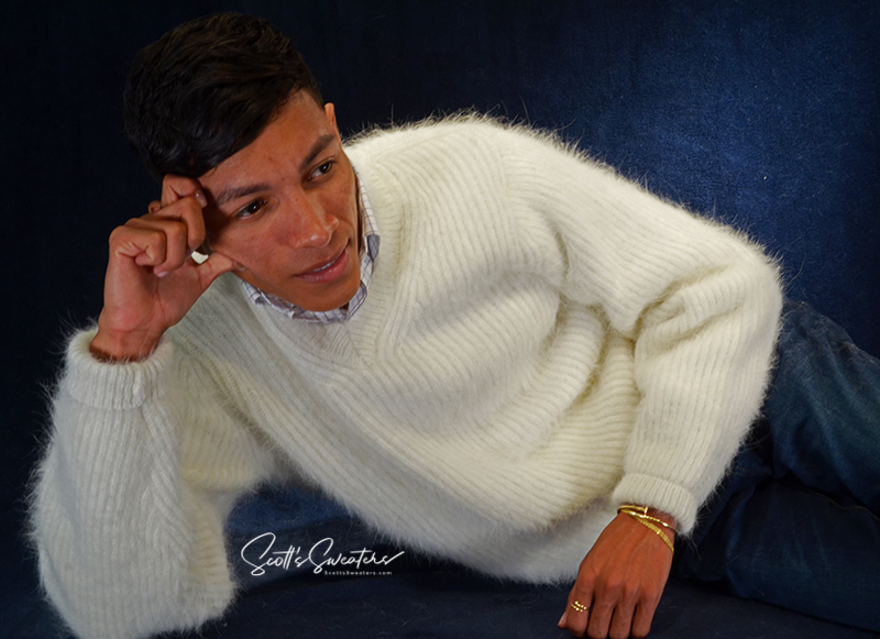 Men's soft luxurious white angora sweater with rib-knit design and V-neck worn by model reclining against dark background