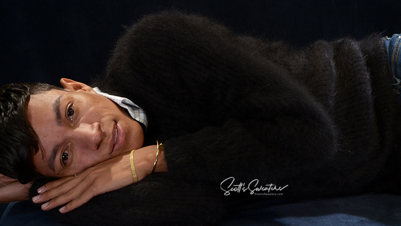 Men's soft luxurious black angora sweater with rib-knit and V-neck design worn by model reclining