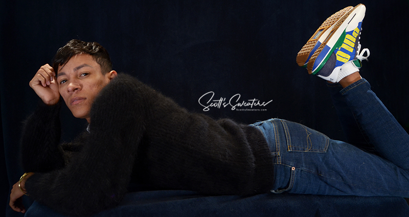 Men's soft luxurious black angora sweater with rib-knit design and V-neck, worn casually with jeans and sneakers.