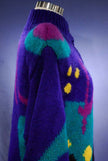 Woman's brightly colored knitted wool sweater-coat with desert motif and vibrant patterns