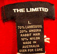 Close-up of The Limited label on teen girl's red short-sleeved angora lambswool sweater showing fabric composition and care instructions.