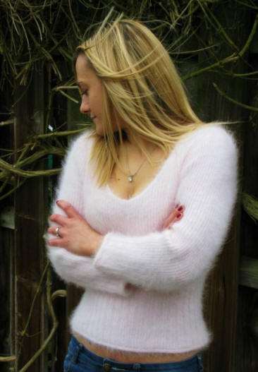 Woman wearing a white fuzzy angora cropped V-neck sweater with 3/4 sleeves outdoors