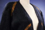Woman's long black mohair blend cardigan with metallic gold crest design on mannequin
