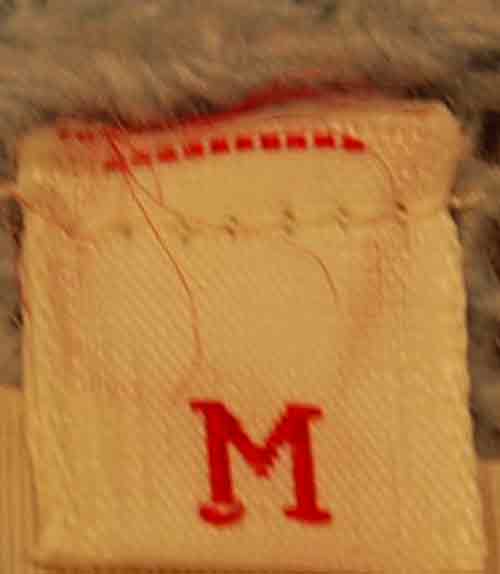 Label tag with size M in red on a wool garment