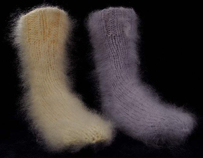 Hand-knit thick warm fuzzy mohair socks in cream and lavender colors on black background
