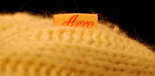 Close-up of yellow girl's cotton and angora sweater fabric with Aeropostale tag