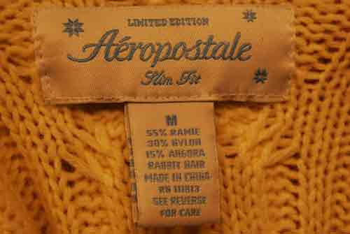Close-up of Aeropostale girl's yellow cotton, ramie, and angora blend V-neck sweater size medium label