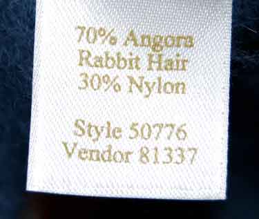 Woman's blue-grey short-sleeved angora sweater label showing material composition and style number