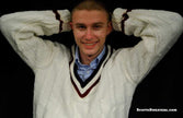 Men's Classic V-neck white cable-knit retro tennis sweater with maroon and navy trim worn by a smiling man