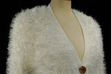 White woman's eyelash cardigan sweater with long fuzzy acrylic fibers and four buttons on mannequin