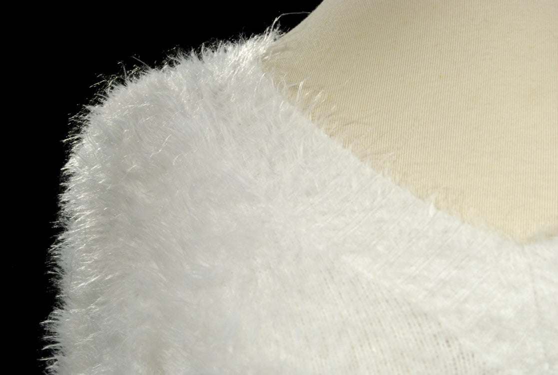 Woman's white ultra-soft fuzzy V-neck sweater on mannequin with extra-long design