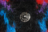 Close-up of metal button on colorful woman’s mohair cardigan sweater by Icelandic design