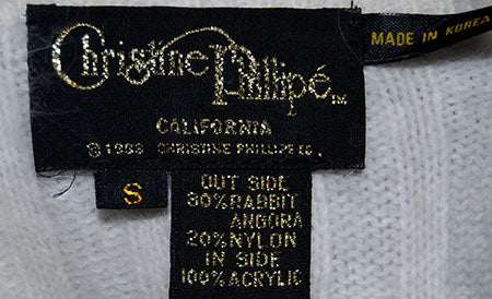 Woman's white angora rib-knit V-neck sweater label with size small and fabric details