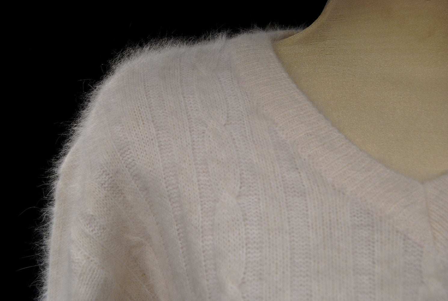 Woman's white angora rib-knit V-neck sweater close-up on mannequin
