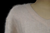 Woman's white angora rib-knit V-neck sweater close-up on mannequin