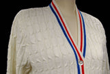White cable-knit retro tennis sweater cardigan with red and blue trim stripes by Orlon Sayelle