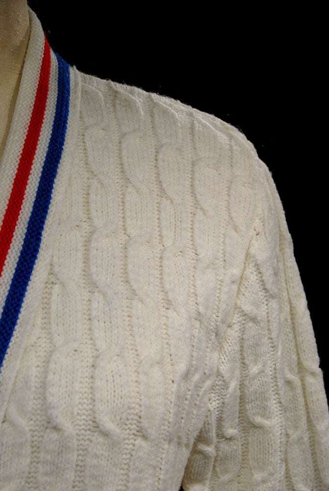 White cable-knit women's tennis sweater cardigan with red and blue trim stripes by Orlon Sayelle