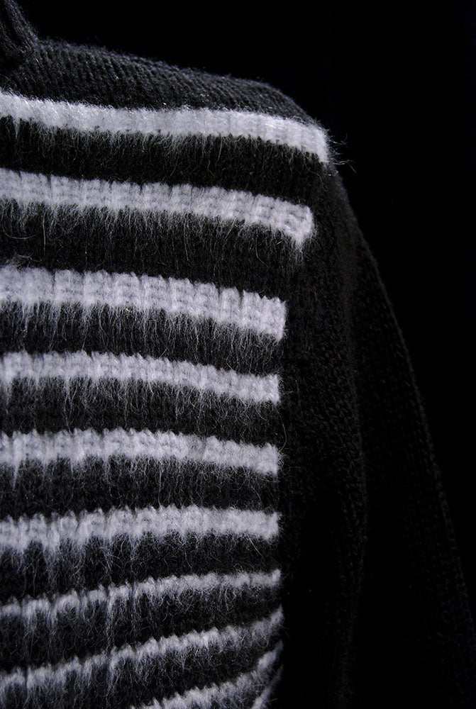 Close-up of men's soft black turtleneck sweater with white horizontal angora stripes.