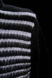 Close-up of men's soft black turtleneck sweater with white horizontal angora stripes.
