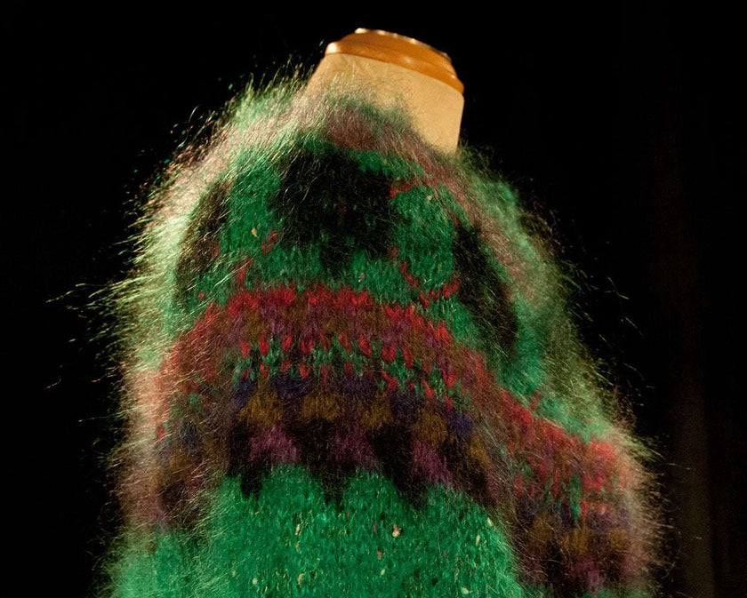 Colorful woman's mohair cardigan sweater with Icelandic design in green, red, and purple tones on a mannequin.