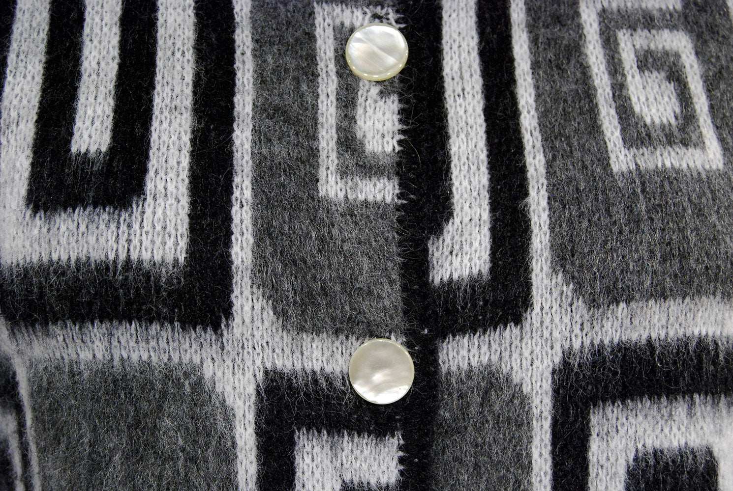 Woman's retro Mad Men's era black white grey faux mohair cardigan sweater with geometric swirl pop-art design and pearl buttons