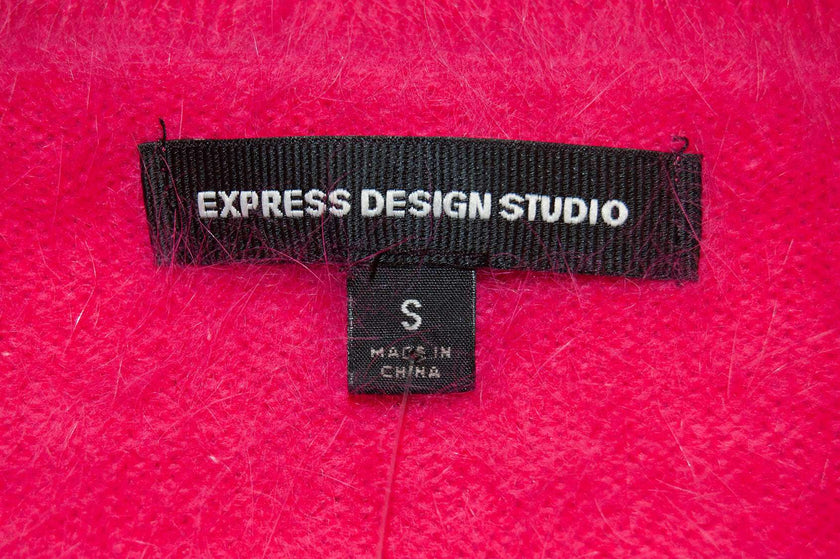 Close-up of Express Design Studio label on bright pink Woman's Angora Shrug cardigan sweater