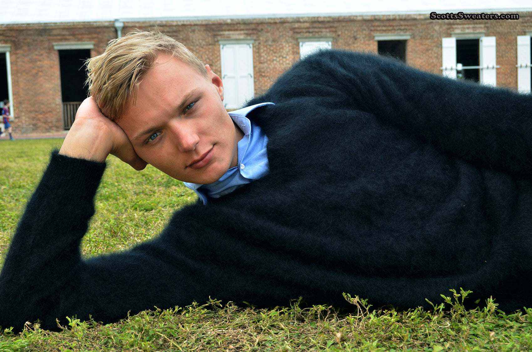 Men's Angora Sweater ultra-soft black angora V-neck sweater model reclining outdoors on grass