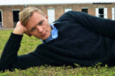 Men's Angora Sweater ultra-soft black angora V-neck sweater model reclining outdoors on grass