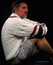 Men's sporty V-neck pullover cotton cable-knit sweater with red and navy striped trim and tennis rackets emblem.