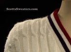 White cable-knit woman's retro cardigan with red and blue trim stripes on collar