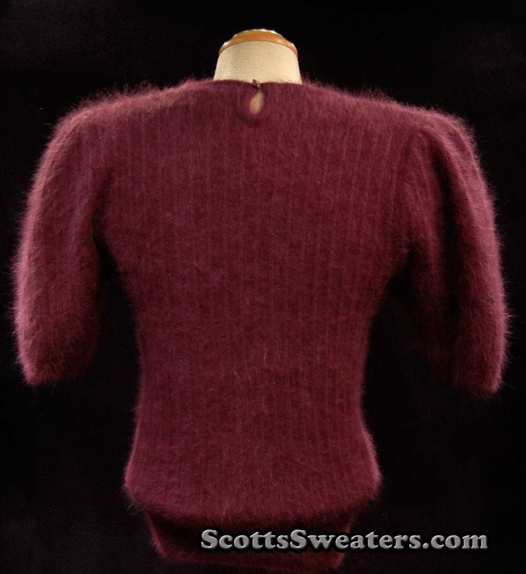 Woman's 2-piece matching deep-purple angora sweater set with short-sleeve top and open-front cardigan featuring leather appliqué