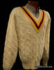 Ivory cable-knit wool tennis sweater with yellow, blue, and red striped V-neck collar