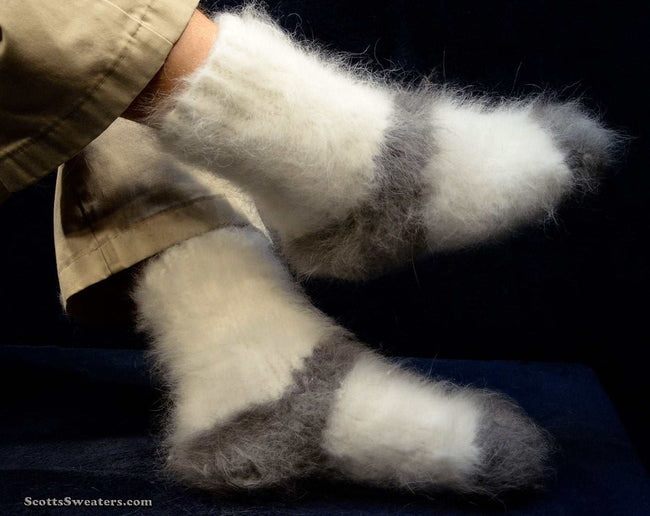 Pair of hand-knit thick and warm Siberian Angora socks in white and gray worn on feet