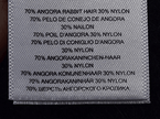 Woman's black V-neck angora sweater by Michael Kors with 70% angora rabbit hair and 30% nylon fabric tag close-up