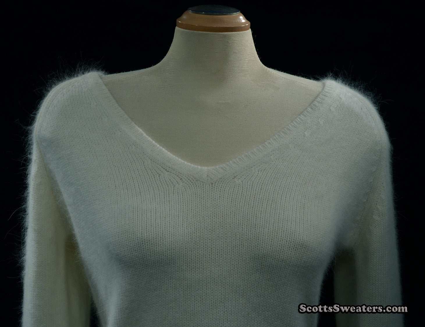 Woman's white angora V-neck sweater with split cuffs by H&M on mannequin