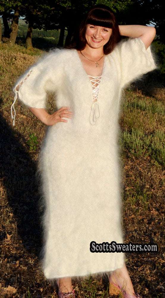 Woman wearing ivory fuzzy mohair full-length sweaterdress with open-lace neckline and half sleeves standing outdoors.