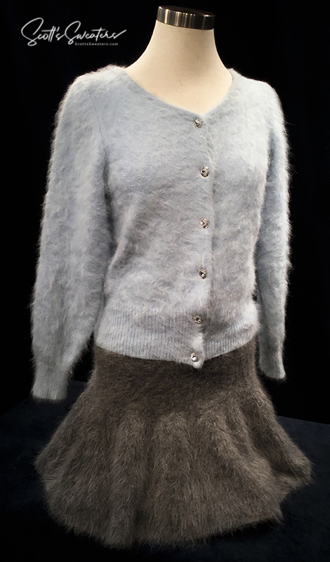 Soft woman’s short angora skirt with elastic waistband in gray shown with light blue angora cardigan on mannequin