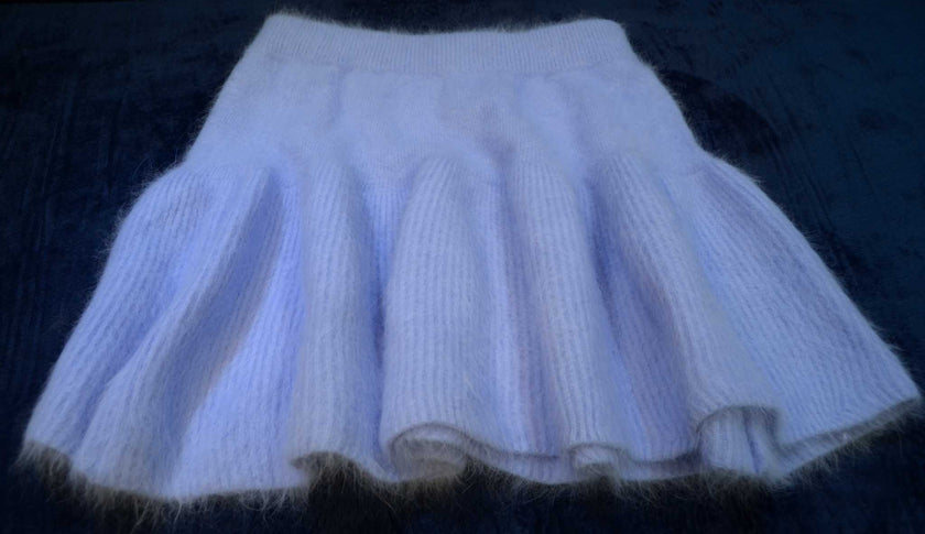 Soft light purple woman's short angora skirt with elastic waistband on dark background