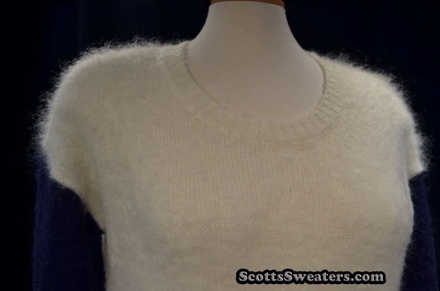 White fuzzy mohair color-block sweater with navy sleeves and roundneck on mannequin