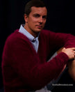 Man wearing a burgundy men's ultra-soft angora cardigan sweater over a light blue shirt against a dark background