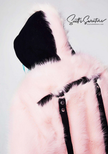 Punk style thick fluffy light pink faux-fur jacket with black hood, hanging straps, and metal D-rings on cuffs.