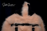 Punk style thick and fluffy faux-fur pink jacket with black hood, hanging straps, and metal D-rings on cuffs
